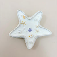 Star-shaped ceramic dish with decorative elements on a beige background