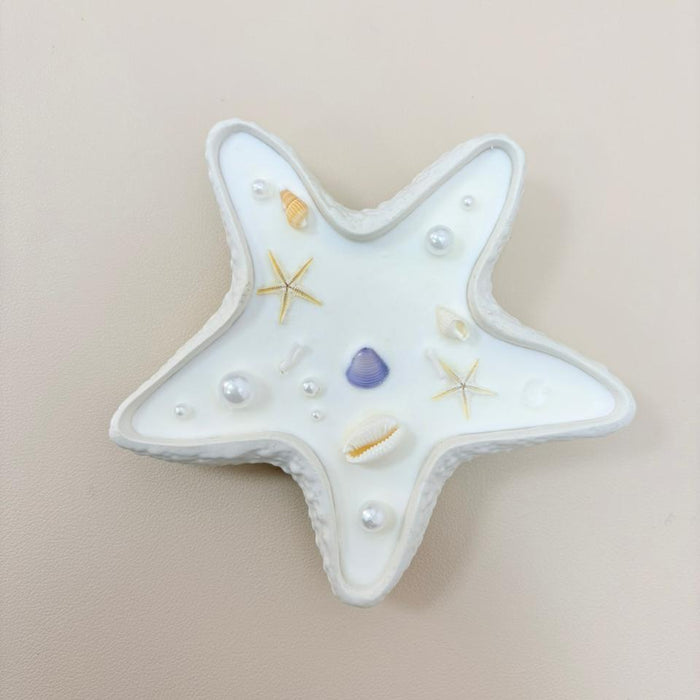 Star-shaped ceramic dish with decorative elements on a beige background