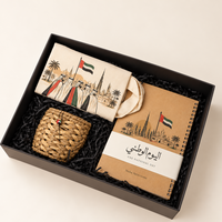 Heritage Essentials UAE National Day 55 gift box featuring a UAE-inspired canvas tote bag, spiral notebook, and handwoven heritage basket inside a premium branded presentation box by Noha Selections.