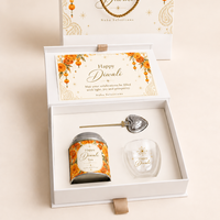 A luxury open white and gold Noha Selections Diwali gift box featuring a branded tea tin, glass teacup, gold heart tea infuser, and festive greeting card.