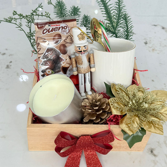Gift basket with candles, Kinder chocolate, and decorative items on a light background