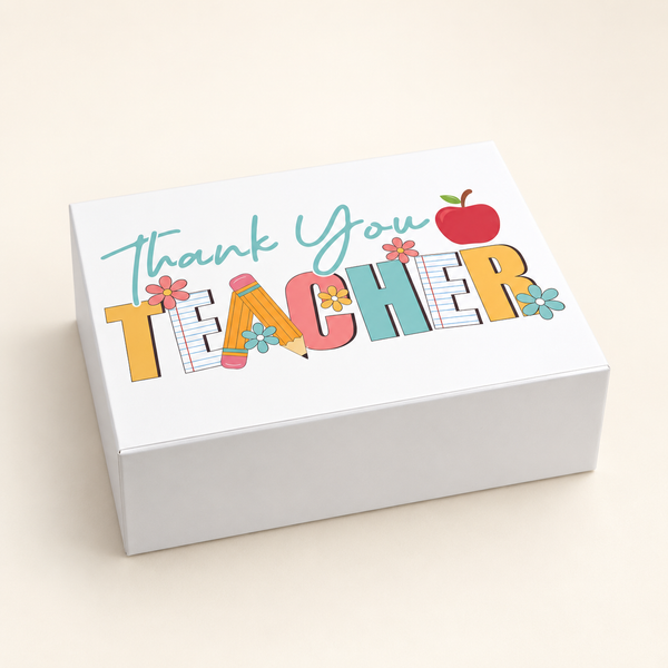 An open white gift box contains a printed teacher mug and two red apple-shaped items, 