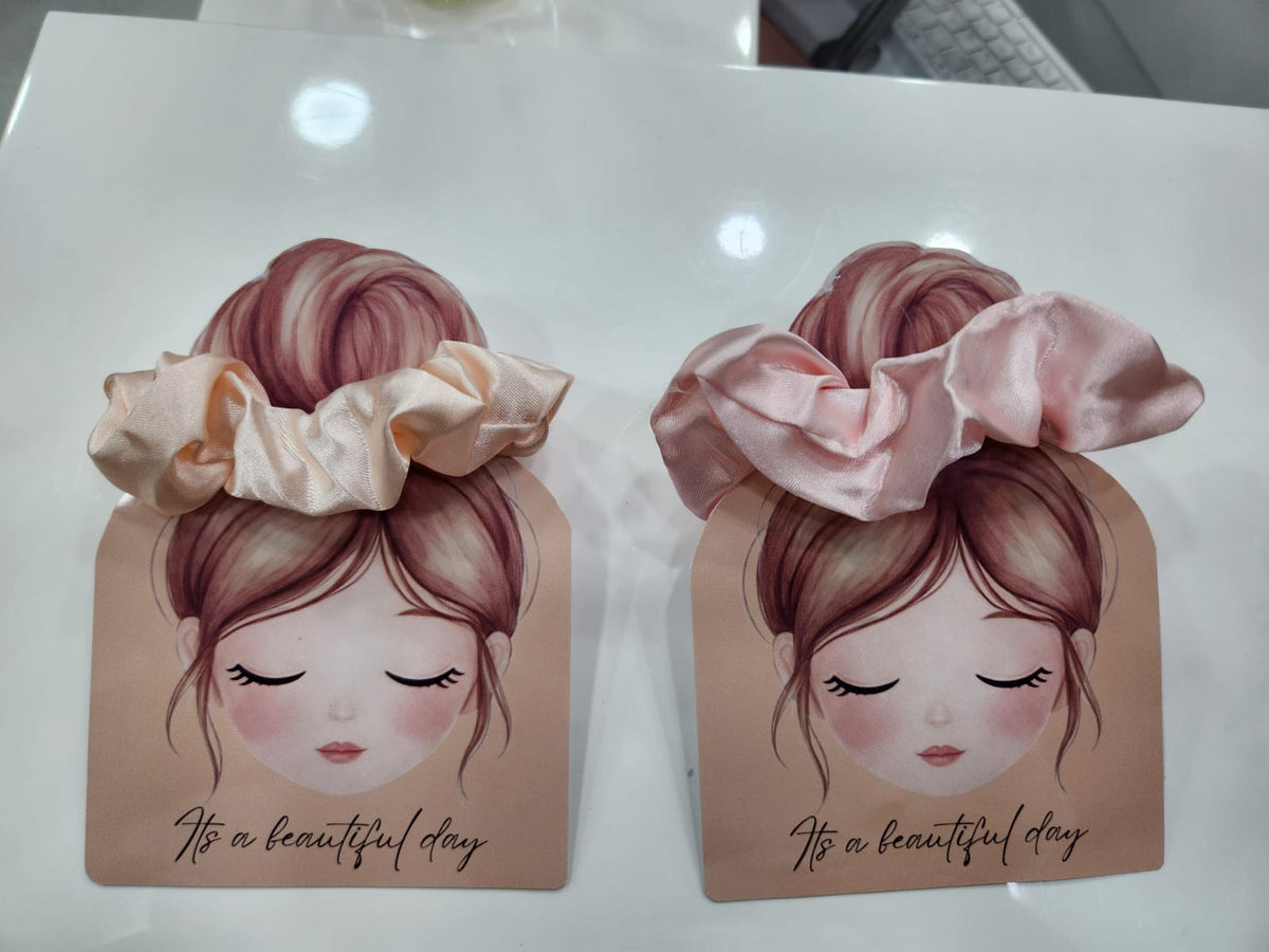 Two decorative boxes with illustrations of a girl with hair accessories on a white surface.