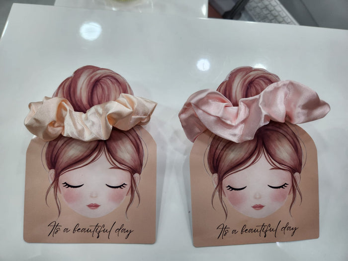 Two decorative boxes with illustrations of a girl with hair accessories on a white surface.