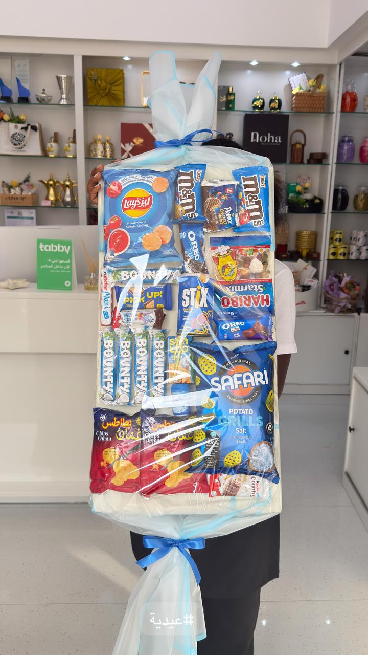 Bouquet of candy packages including KitKat, M&M's, and Safari in a store setting.