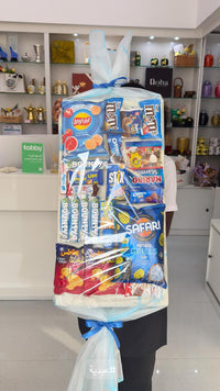 Bouquet of candy packages including KitKat, M&M's, and Safari in a store setting.