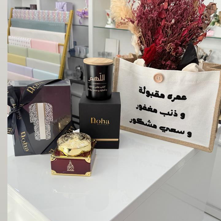 Decorative setup with candles, flowers, and a sign on a white surface.
