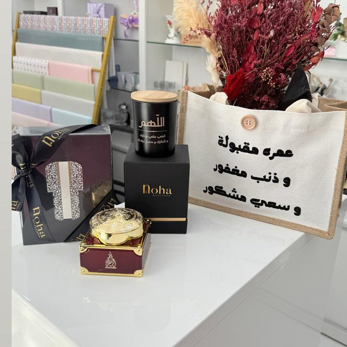 Decorative setup with candles, flowers, and a sign on a white surface.